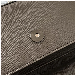 Close-up of Saffiano leather texture and round magnetic closure on the handbag