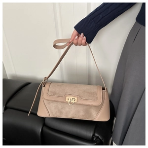 Close-up of beige shoulder bag featuring mixed leather textures and gold twist lock