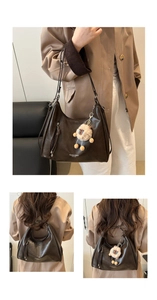 Detail view of large dark brown hobo shoulder bag with a cute plush sheep pendant