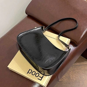 Minimalist black retro underarm bag with glossy textured leather on a 45-degree angle view