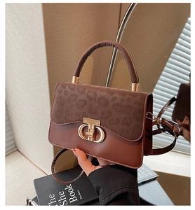 Close-up of retro leopard print patchwork handbag with golden horseshoe buckle details