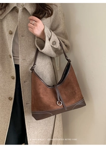 Detail of retro suede crescent tote with contrast stitching and metal ring buckle