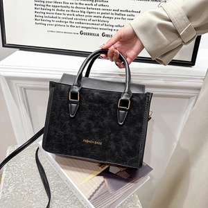 Borsa a mano nera minimalista con scritta dorata e tracolla regolabile per donna