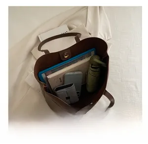 Interior view of brown leather tote bag showing large capacity for tablet and daily items