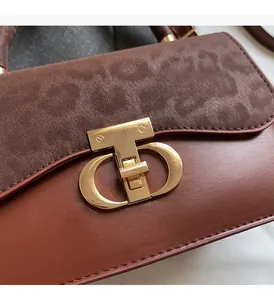 Detail of vintage brown leather bag with leopard print suede and gold T-shaped clasp