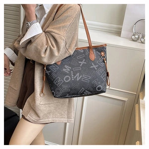 Dettaglio della borsa shopper capiente con stampa geometrica e manici in pelle marrone