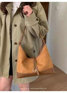 Detail of caramel brown suede and leather shoulder bag with fine contrast stitching