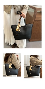 Detail of black tote bag with vintage chain print scarf on handle and sleek matte PU finish