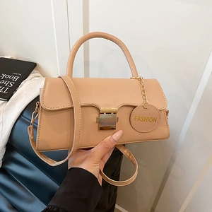 Sac bandoulière beige chic avec poignée et fermoir doré présenté dans un cadre d'intérieur