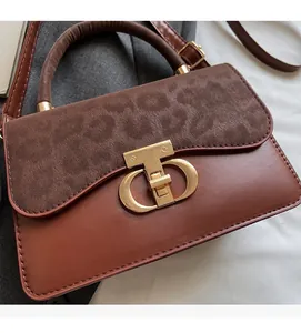 Detail of leopard print flap bag with gold T-lock and textured brown leather material