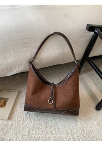 Close-up of brown suede tote bag with contrast stitching and silver ring detail