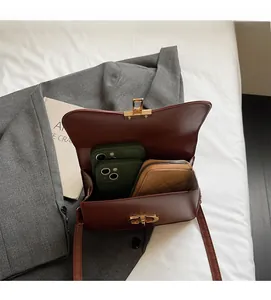 Interior view of vintage brown leather bag showing capacity for two phones and a long wallet