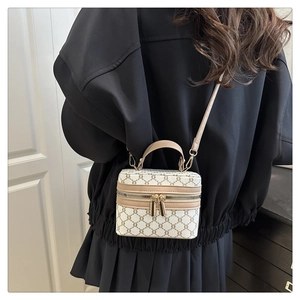 Detail of vintage logo pattern crossbody bag with leather trim and gold zippers