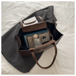 Macro view of a large brown monogram tote bag showing spacious interior for tablets