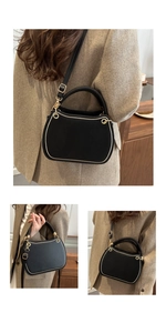 Close-up of black leather handbag with gold metal hardware and adjustable shoulder strap