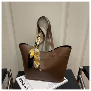 Detailed view of deep coffee tote bag with matte leather and decorative silk scarf