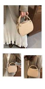 Detail showing beige minimalist shoulder bag with gold metal rings and top handle detail