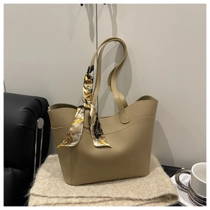 Close-up of khaki tote bag with a decorative silk scarf and textured PU leather