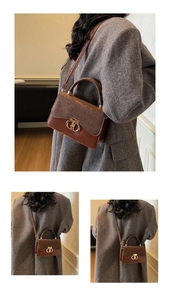 Detail of a brown leather and suede crossbody bag with a gold buckle on a grey wool coat