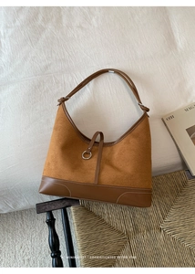 Detail of retro brown tote with suede finish and silver ring buckle accent