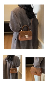 Detail of leopard print flap and gold clasp on brown leather crossbody handbag
