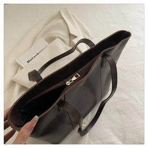 Top view of large dark brown tote bag showing gold zipper and spacious interior