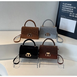 Detail view of four textured crossbody bags with gold CD hardware and leopard patterns