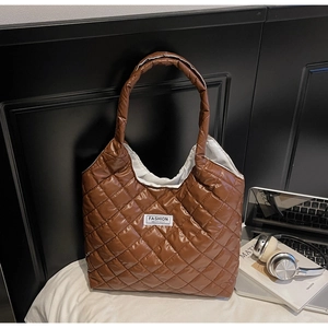 Detail of brown quilted tote bag with large capacity and Fashion Instinct label
