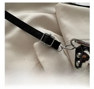 Detailed shot of silver hardware and studs on a leopard print tote bag with leather strap