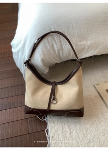Detail of retro suede and leather stitching with metal ring buckle on minimalist tote bag