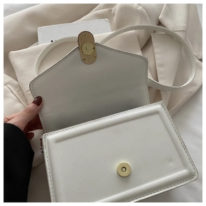 Detail view of the open white square flap bag showing the magnetic closure and interior