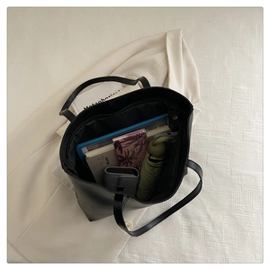 Top-down view of a spacious black tote bag showing interior storage for books and umbrella