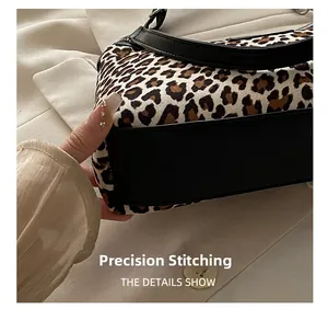Detailed view of precision stitching on a leopard print handbag with leather base