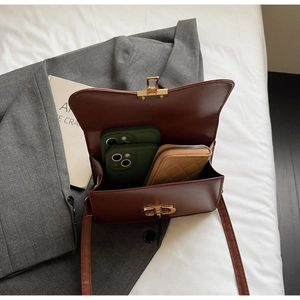 Detail of brown leather bag interior with CD lock showing storage for phones and wallet