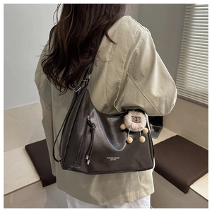 Borsa hobo in pelle testa di moro con zip verticale e ciondolo a pecora indossata da modella