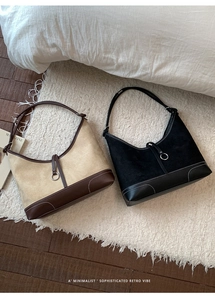 Close-up of suede tote bags with contrasting leather trim and metal ring details