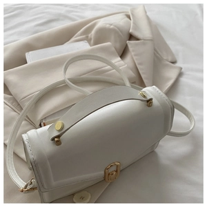 Detail of white leather handbag with golden buckle and adjustable thin shoulder strap