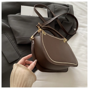 Detailed view of the dark brown asymmetrical leather handbag with elegant gold hardware
