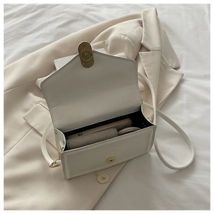 Macro view of white PU leather square bag with vintage metal magnetic buckle detail