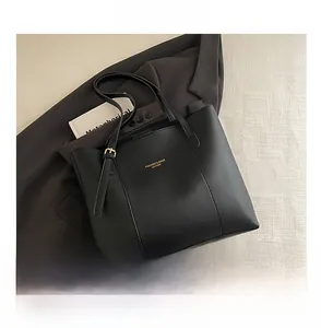 Detailed comparison of the black faux leather tote bag size with a smartphone device