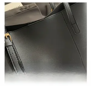 Detail of lychee pattern leather tote with gold foil fashion logo and metal buckle