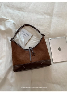 Detail of brown suede tote bag with contrast white stitching and silver ring buckle