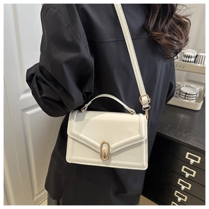 On-body view of a white leather square crossbody bag with elegant gold oval clasp