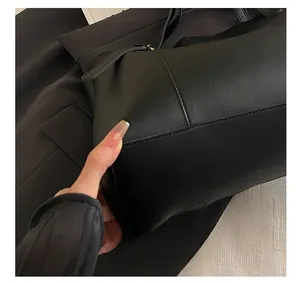 Macro shot of high-quality precision stitching on the black matte leather tote bag