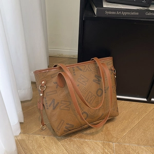 Borsa tote in pelle marrone con stampa di lettere su pavimento in legno in stile chic