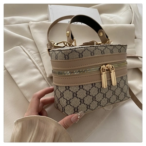 Detail of vintage patterned box crossbody bag with dual metal zippers and leather trim