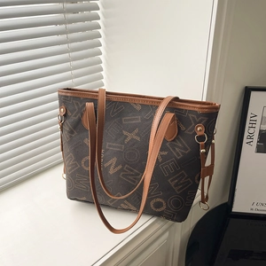 Elegante borsa tote marrone con stampa di lettere e manici in pelle su davanzale bianco