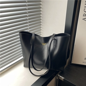 Large black tote bag with gold lettering and pleated texture for stylish commuting