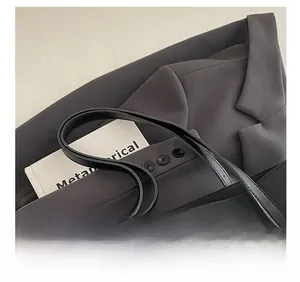 Close-up of comfortable shoulder straps and gold lettering on a black textured tote bag