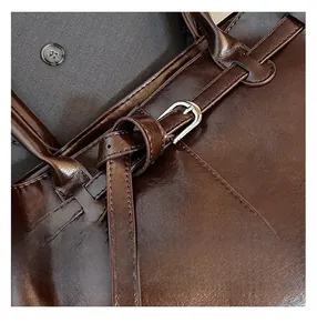 Close-up of dark brown leather shoulder bag showing precise stitching and silver buckle